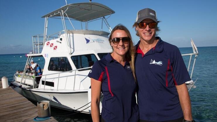 picture of the two owners of Living the dream divers standing together with boat in background