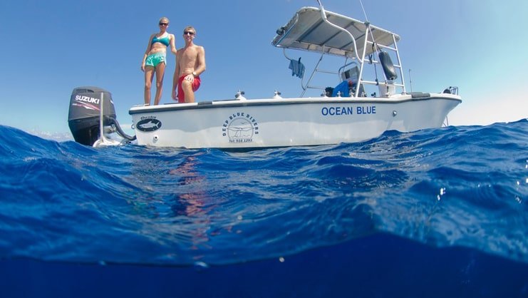 two people standing on boat in the sea