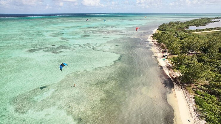 picture of barkers beach from air with people kitesurfing in the distance