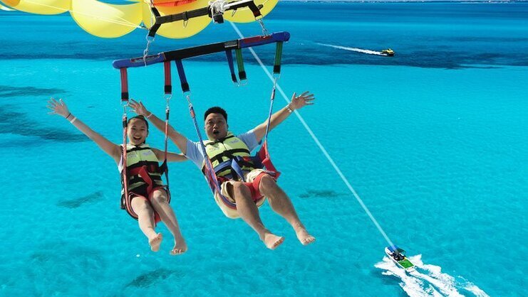 picture of two people parasailing high in the sky