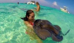 picture of a girl holding a stingray in the water