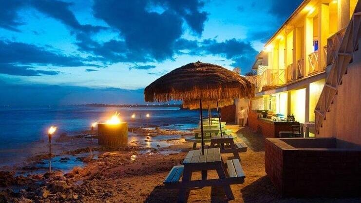 picture of benches near water at sunset at south coast bar and grill