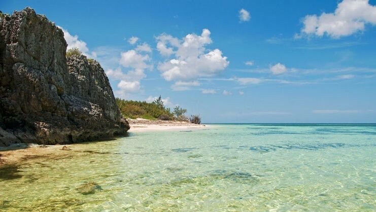 picture of 20 foot tall cliff at barefoot beach with shallow water