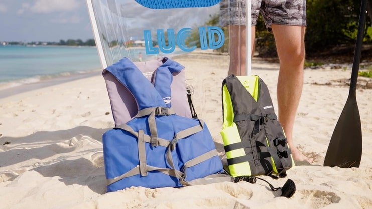 image showing two life jackets and an ankle leash on the beach